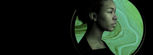 Profile of a young woman in front of a green, marbled circular background on a black backdrop.