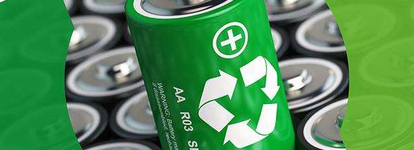 A green AA battery with a recycling symbol stands out among other batteries in the background.