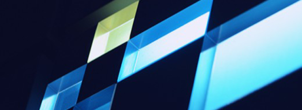 Abstract geometric shapes in blue and yellow, forming a grid pattern with glowing light and shadow effects.