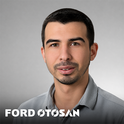 Man with short dark hair and beard in grey polo shirt, with FORD OTOSAN logo at the bottom, on a grey background.